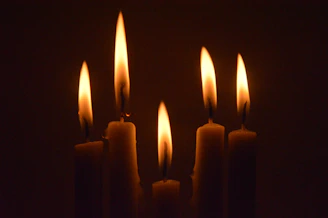 a group of lit candles in a dark room
