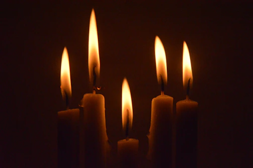 a group of lit candles in a dark room