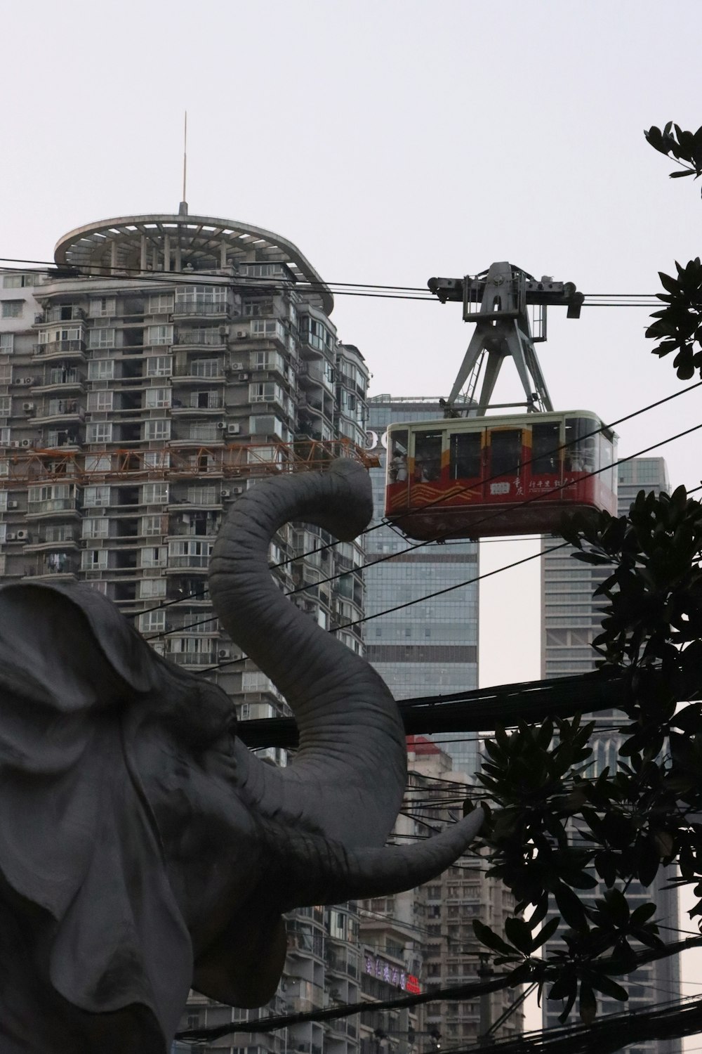 a statue of an elephant with a cable car in the background