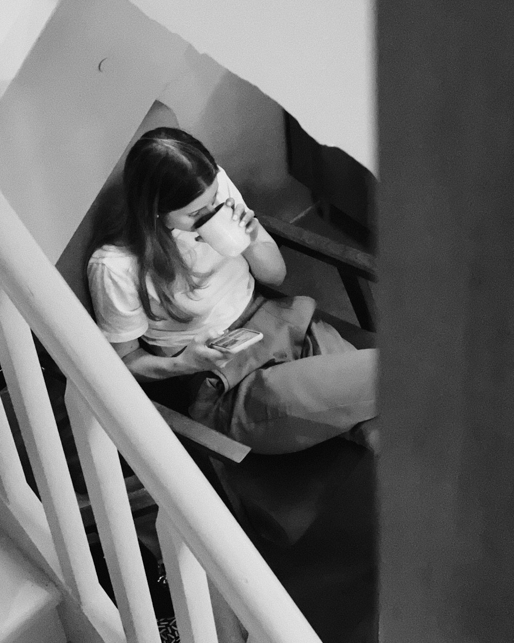 a woman sitting on a stair case reading a book