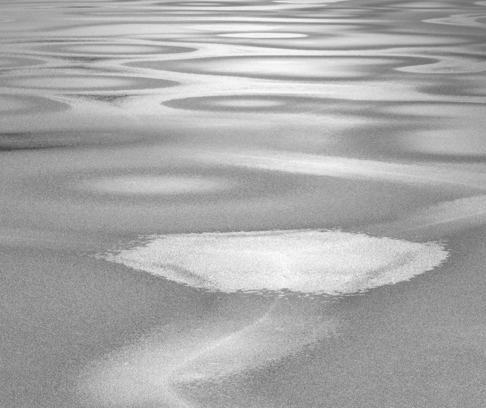 a black and white photo of water and sand