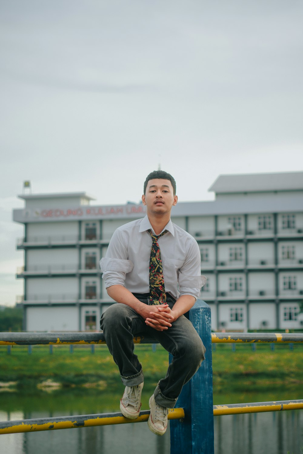 a man sitting on a post in front of a building