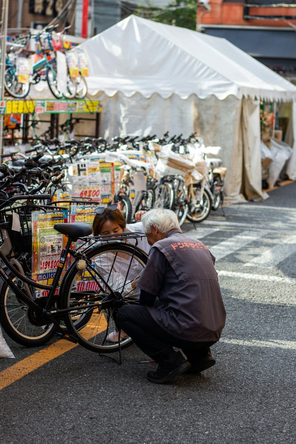a man kneeling down next to a parked bike