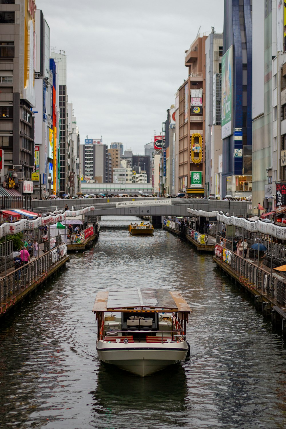 a boat traveling down a river next to tall buildings