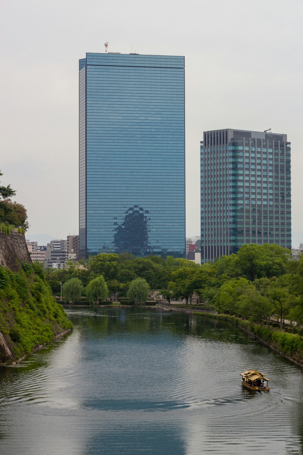 a boat traveling down a river next to tall buildings