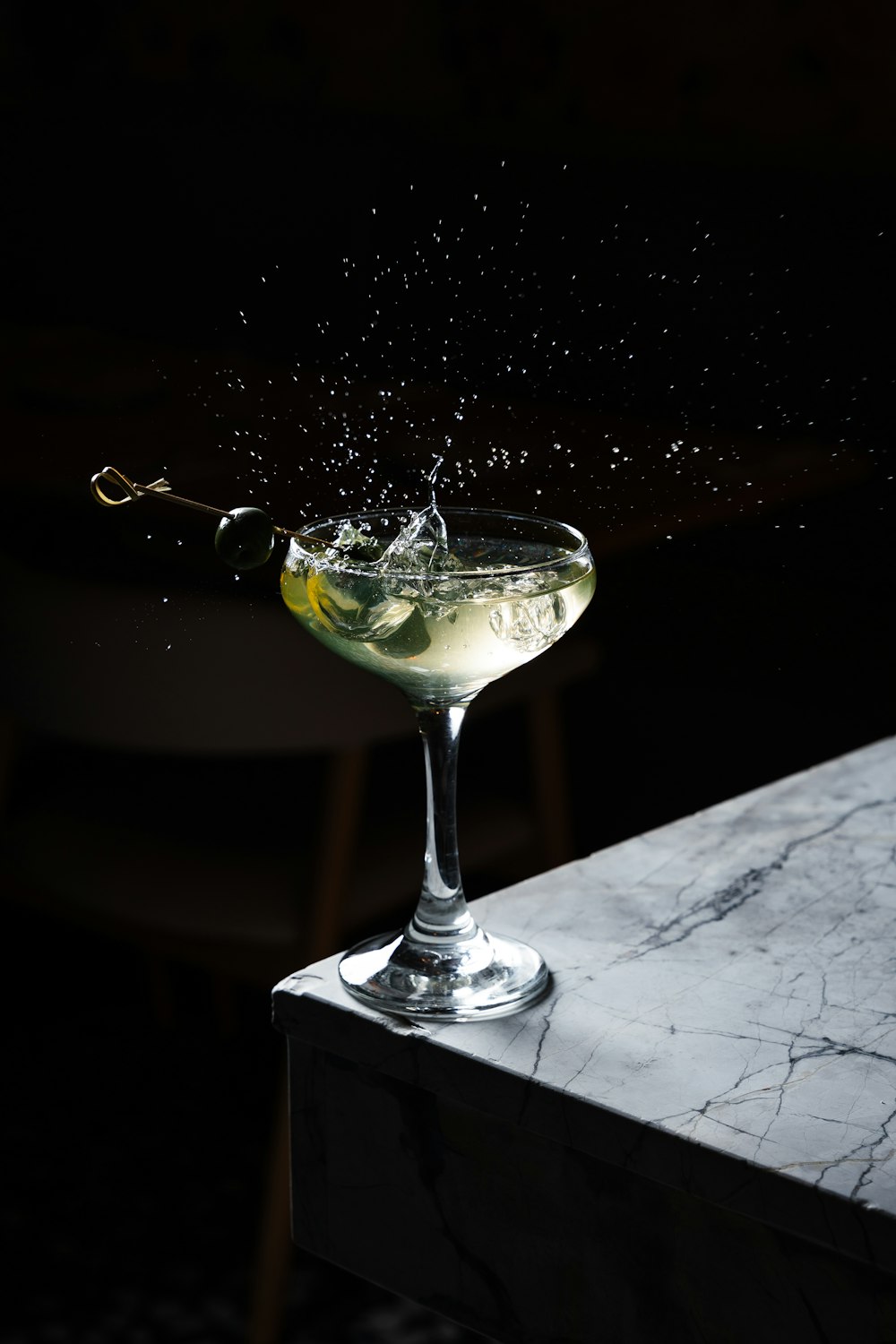 a martini with a splash of water on top of it