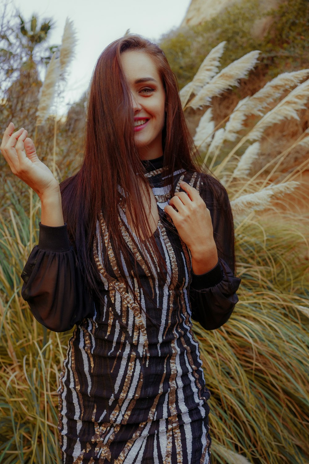 a woman standing in a field of tall grass