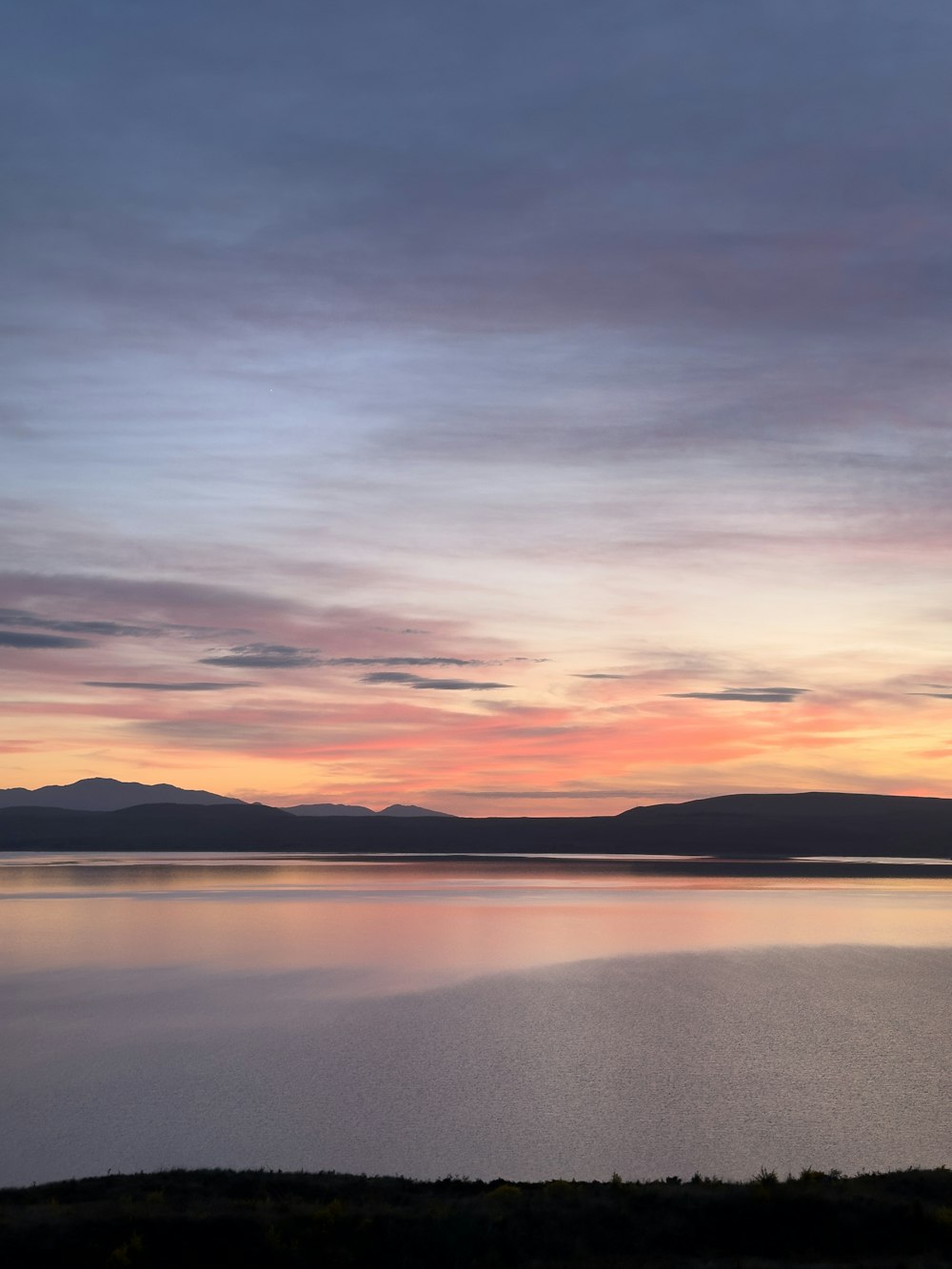 une grande étendue d’eau sous un ciel nuageux