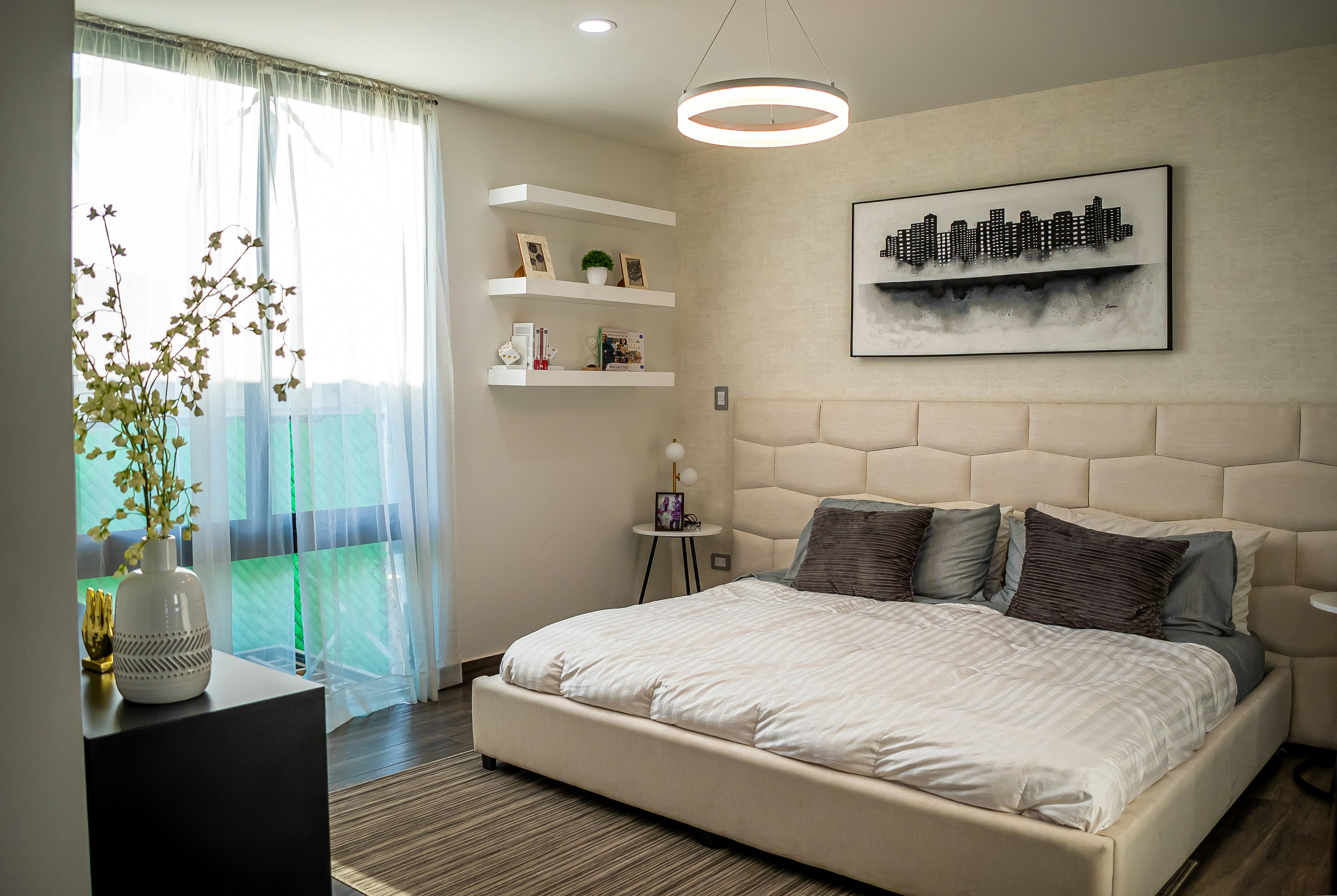 Spacious industrial loft with floor-to-ceiling sheer curtains filtering natural light over modern art collection