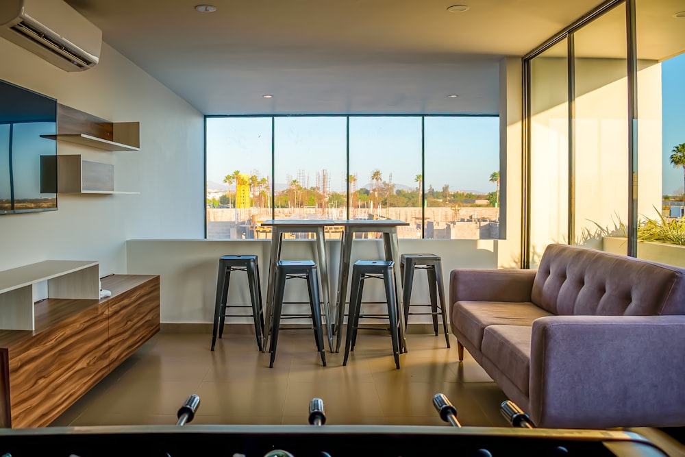 a living room filled with furniture and tall windows