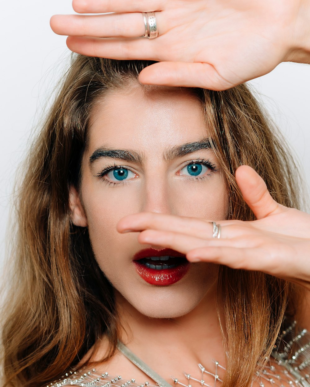 a woman with blue eyes and a ring on her finger