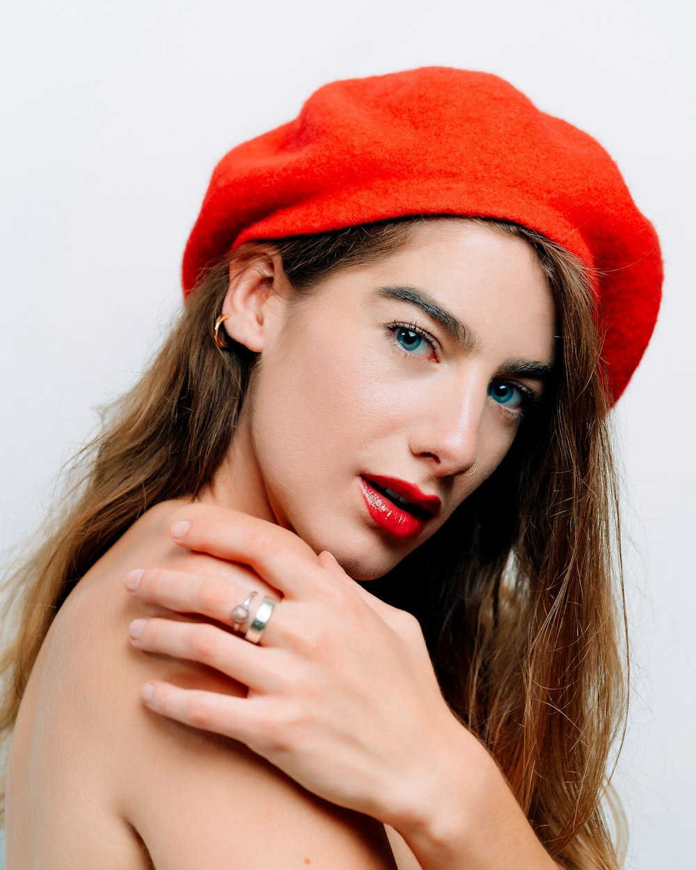 a woman wearing a red beret and a ring