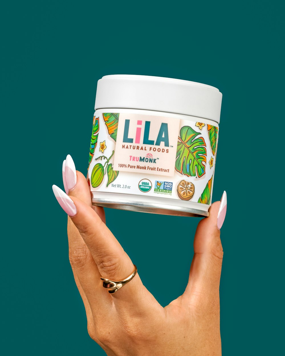 a woman's hand holding up a jar of lila