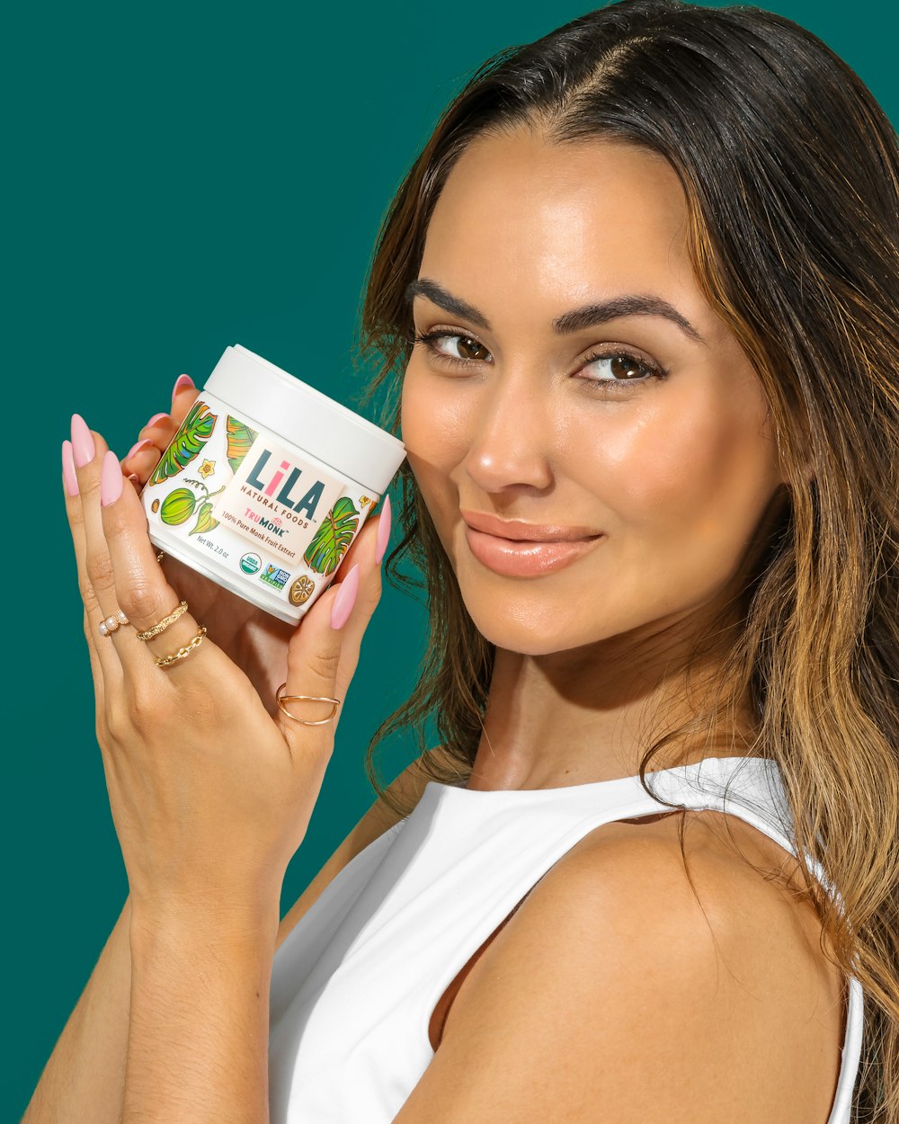 a woman holding up a jar of lip balm