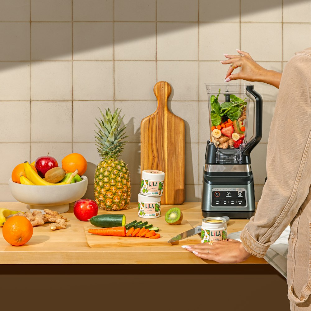 a woman standing in front of a counter filled with fruits and vegetables