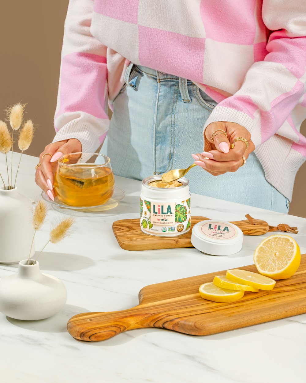 a woman is holding a spoon over a jar of honey