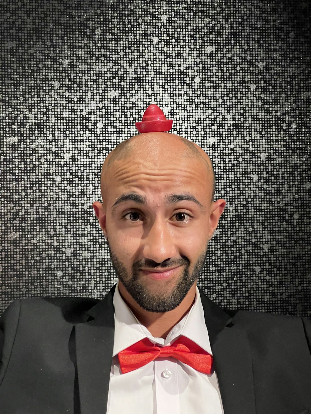 a man with a bald head wearing a red bow tie