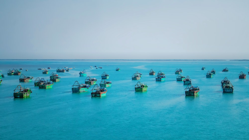 a large group of boats floating in the ocean