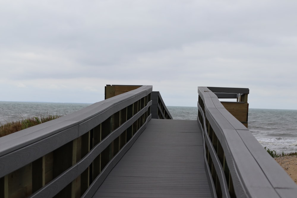 a walkway leading to a bench on the beach