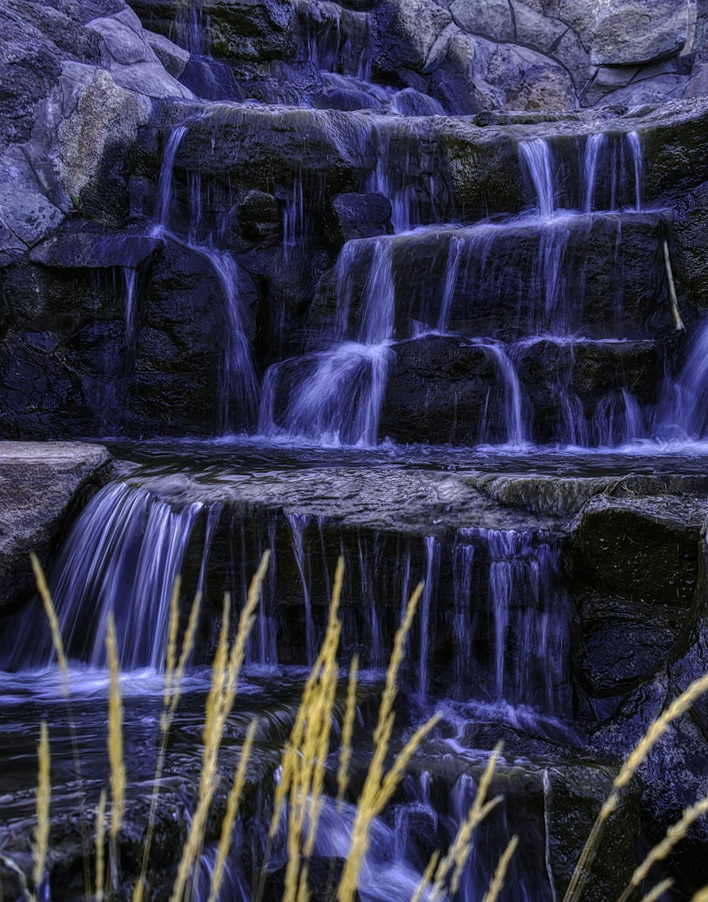 a waterfall with water cascading down it's sides