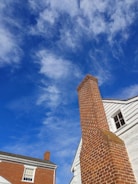 a tall brick chimney sitting next to a white building