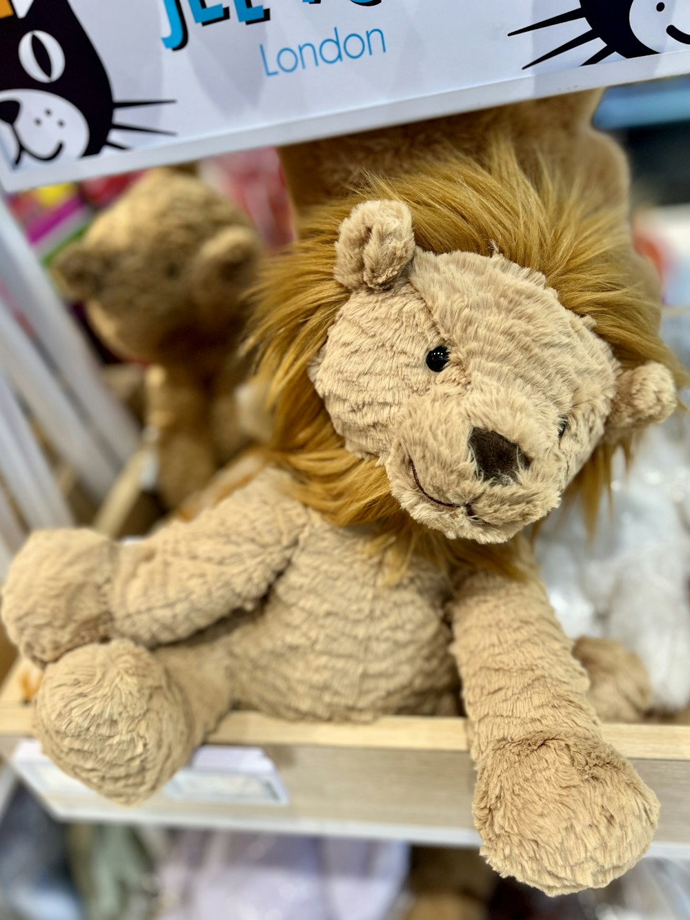 a stuffed lion sitting on a shelf in a store