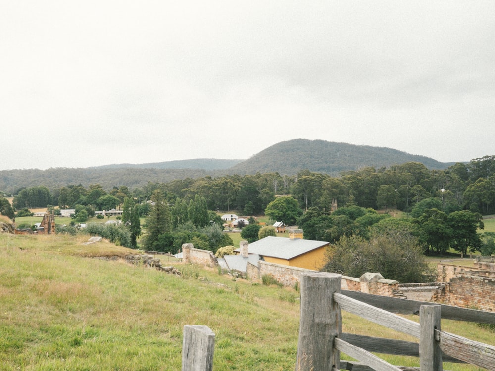 a wooden fence in front of a grassy field