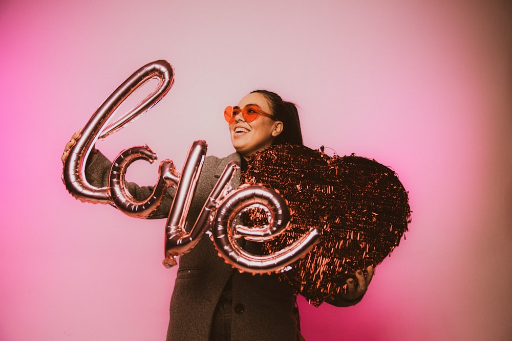 a woman in a suit and sunglasses holding a balloon