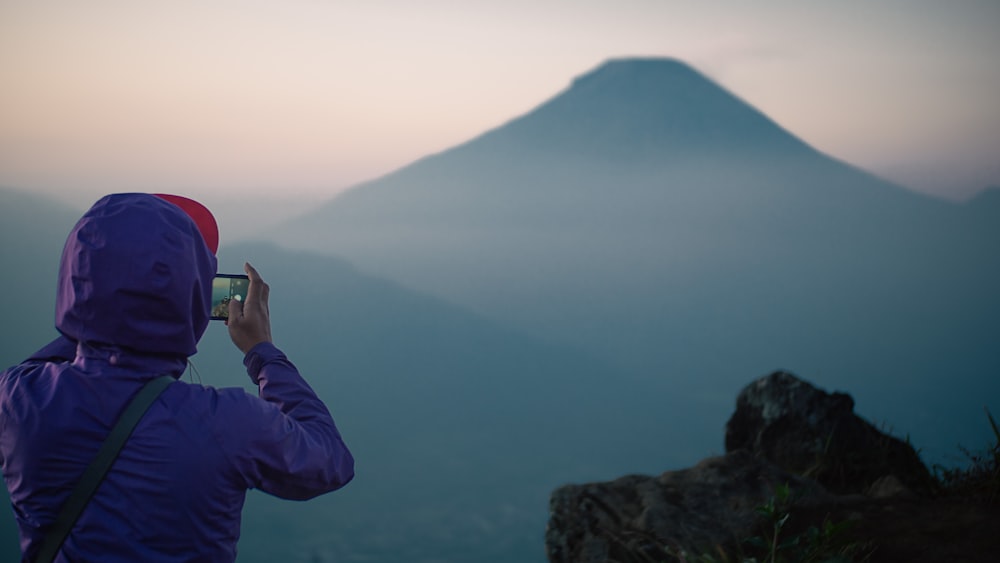 a person taking a picture of a mountain