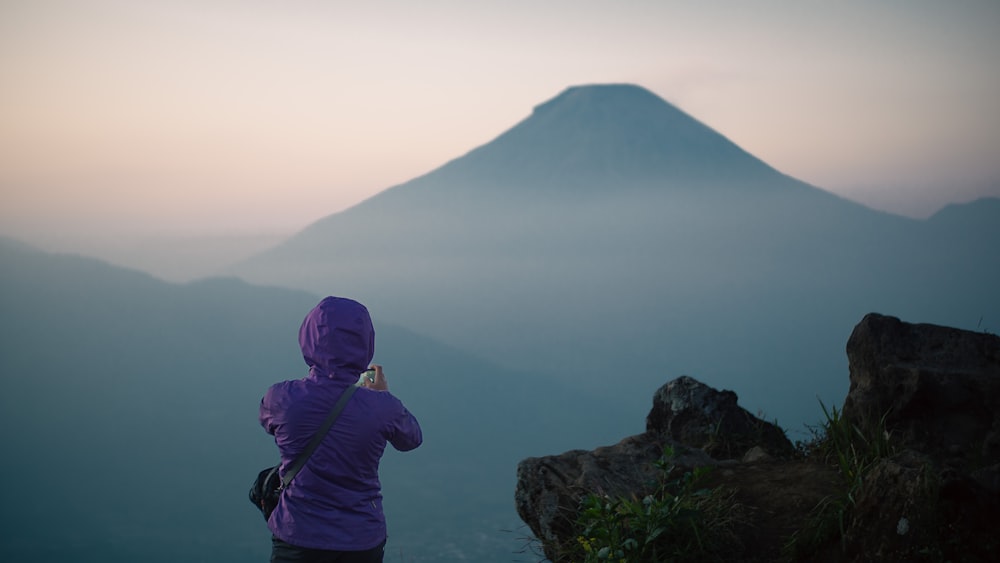 a person taking a picture of a mountain