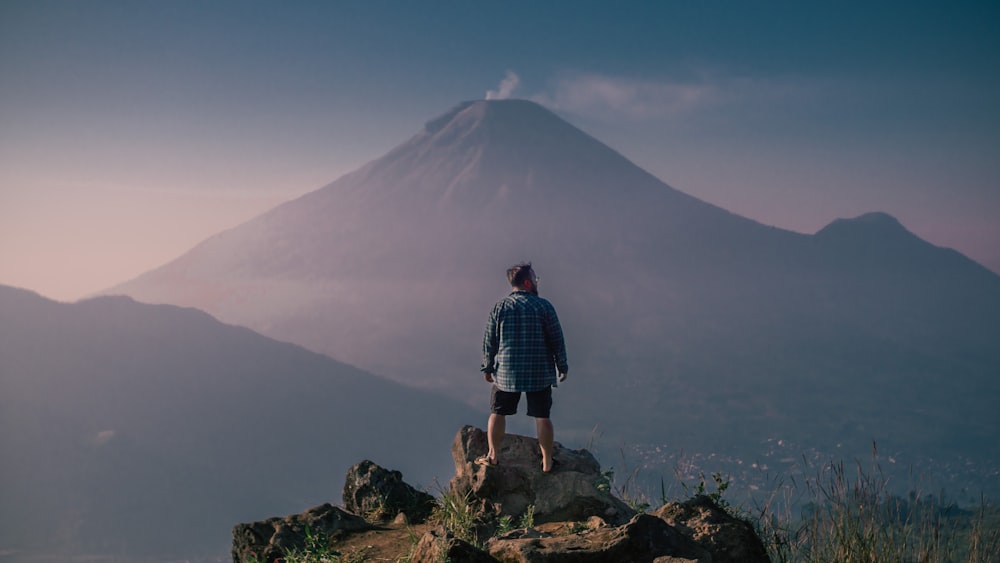 a man standing on top of a large rock