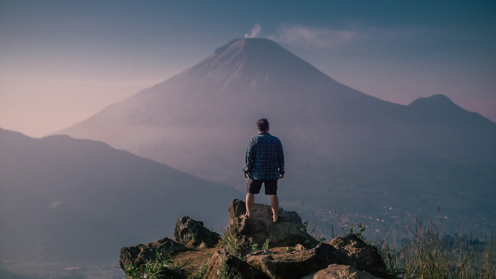 a man standing on top of a large rock