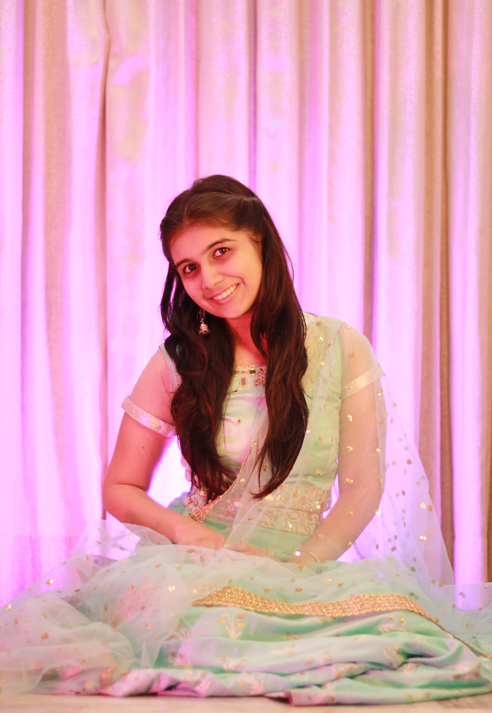 Woman in a pista green lehenga with pastel backdrop