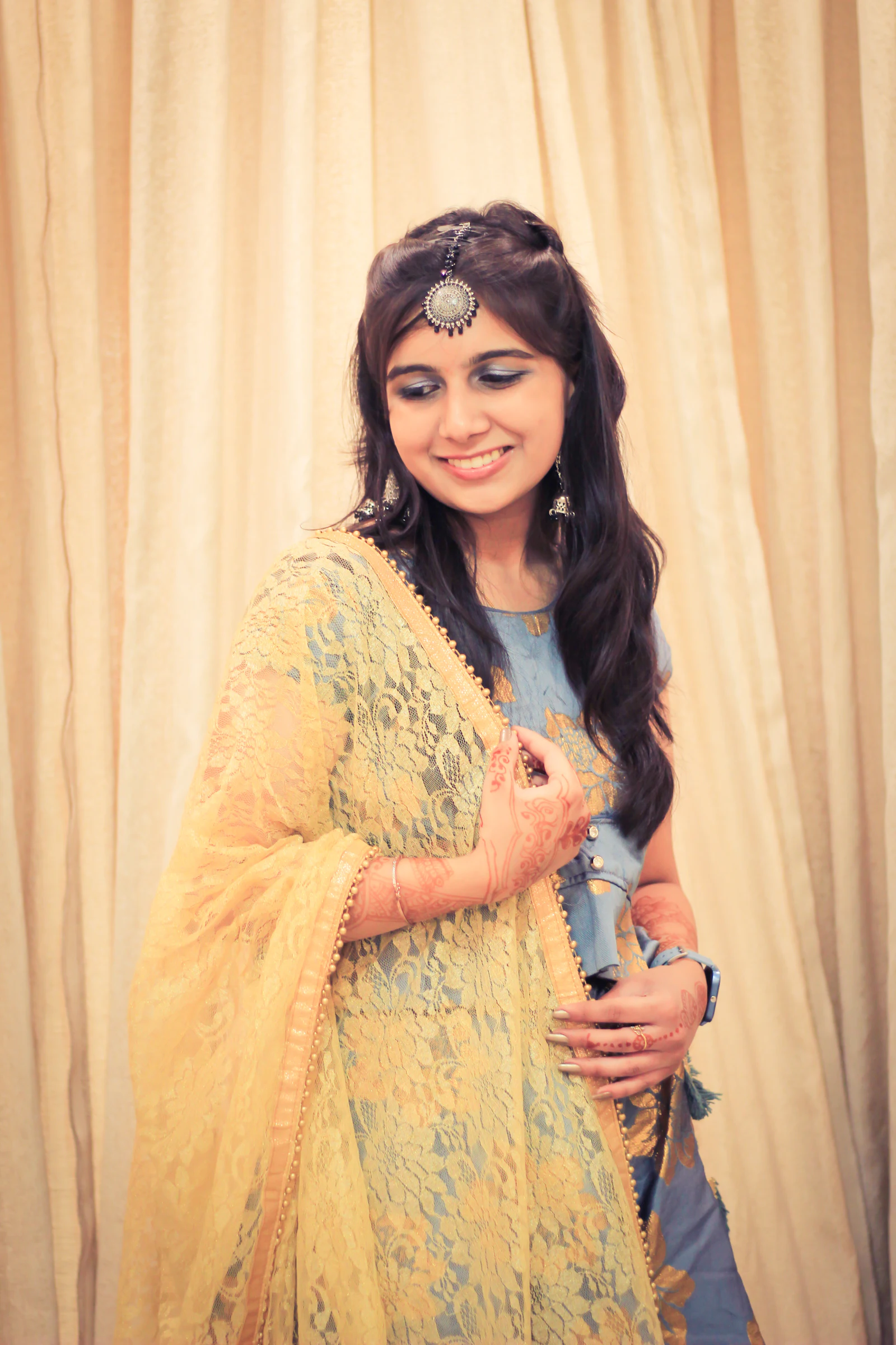 Smiling woman in a yellow kurta with a sheer dupatta