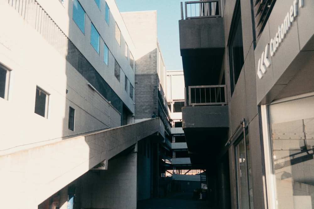 a narrow alley way between two buildings with balconies