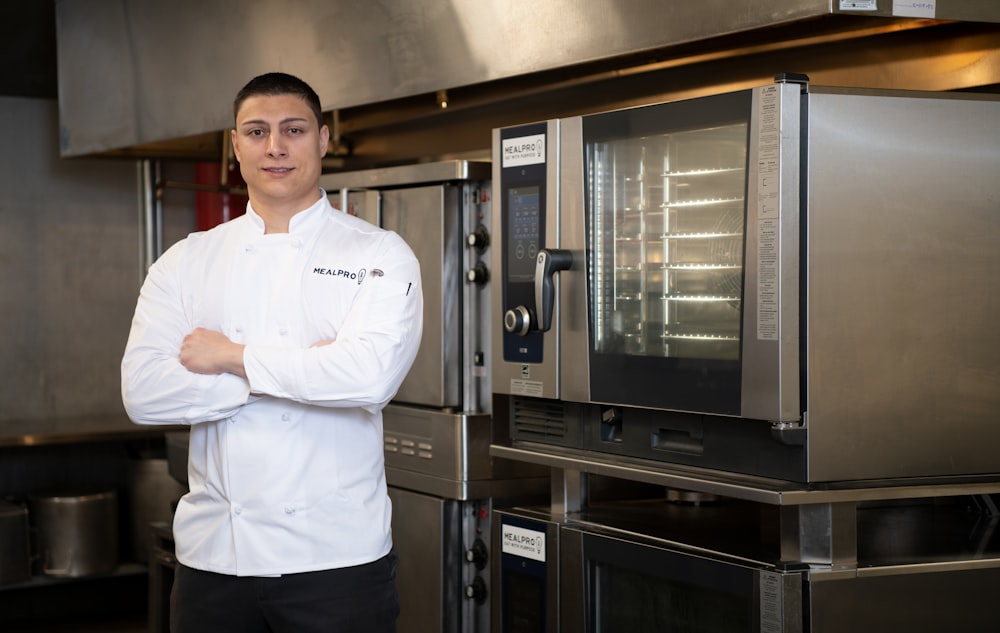 a man standing in front of an oven in a kitchen