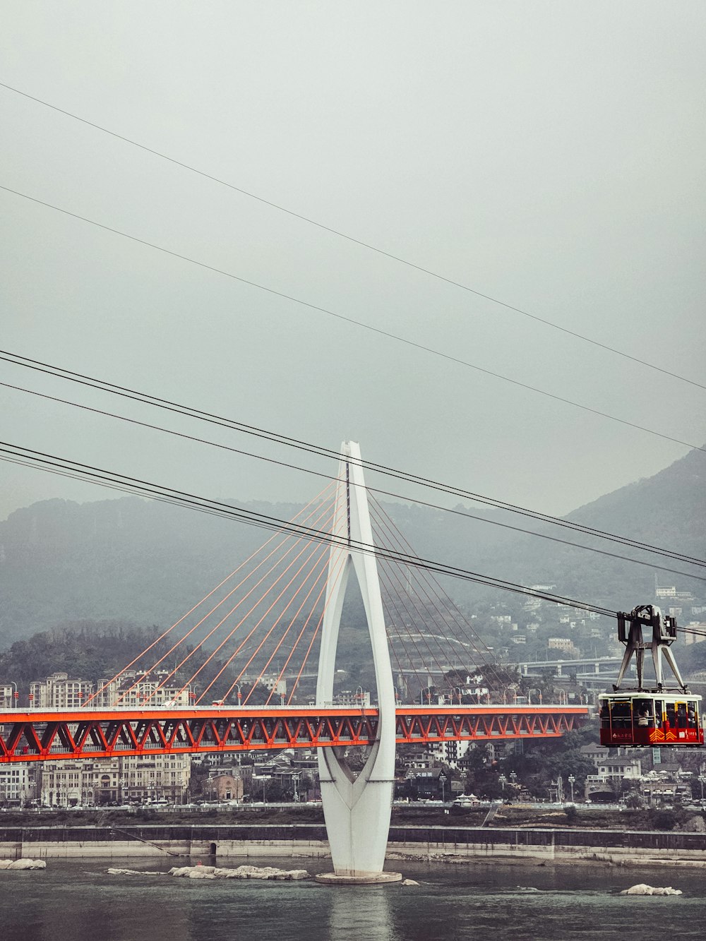 um teleférico está passando por cima de uma ponte