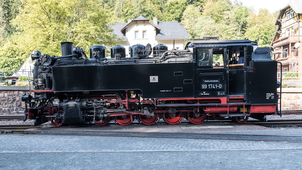 a black and red train is on the tracks