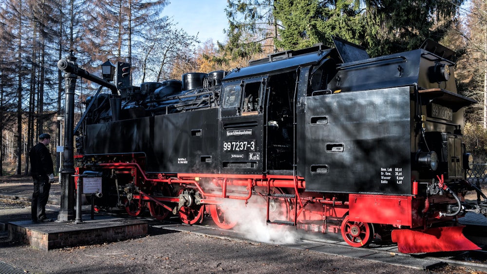 a black and red train engine sitting on the tracks