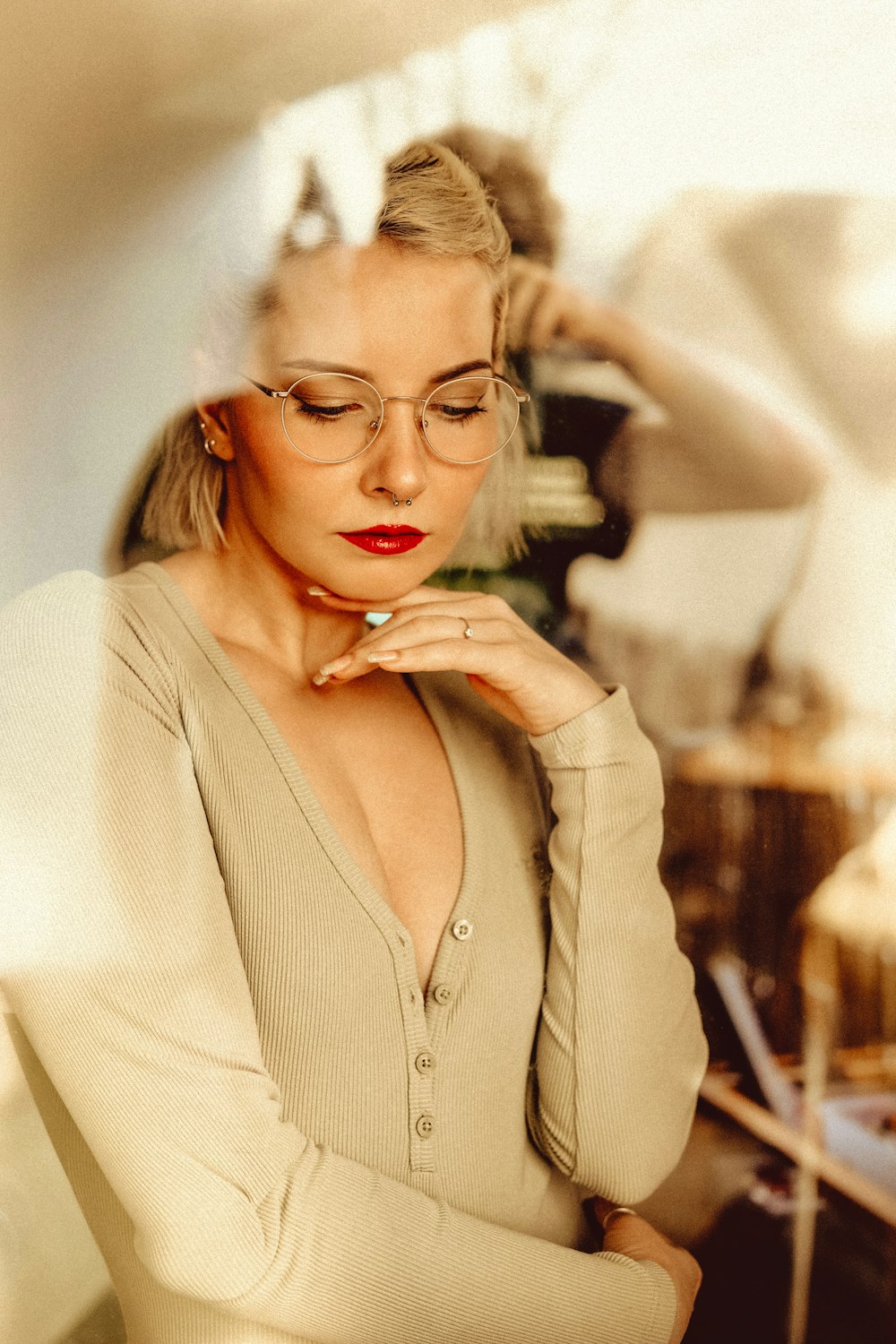 a woman with glasses is leaning against a wall