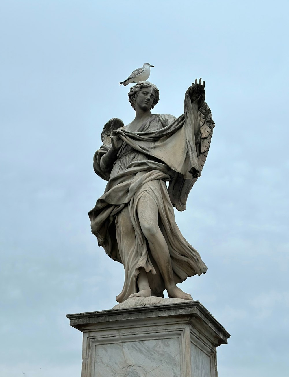 a statue of a woman with a bird on her shoulder