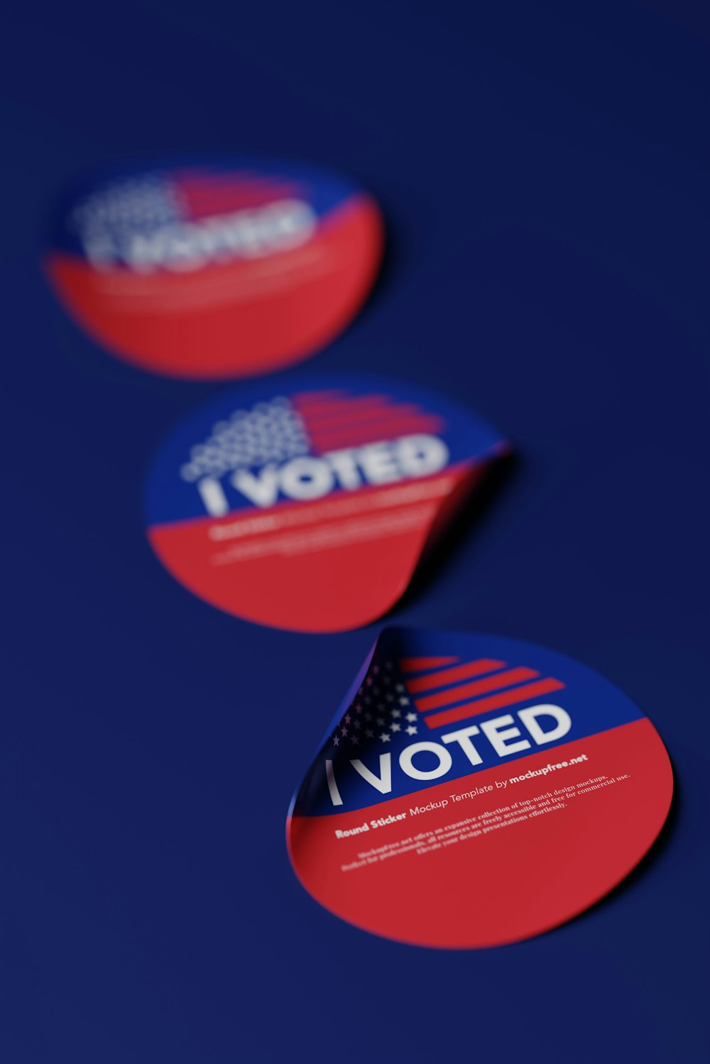 three red, white, and blue stickers on a blue surface