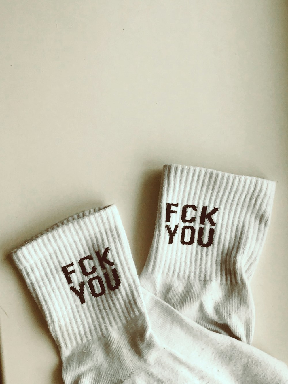 two pairs of socks with the words f k you on them