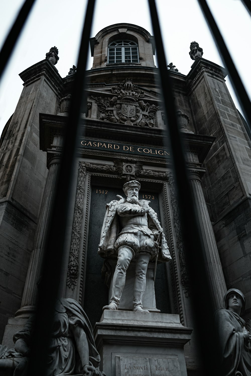 a statue of a man standing in front of a tall building