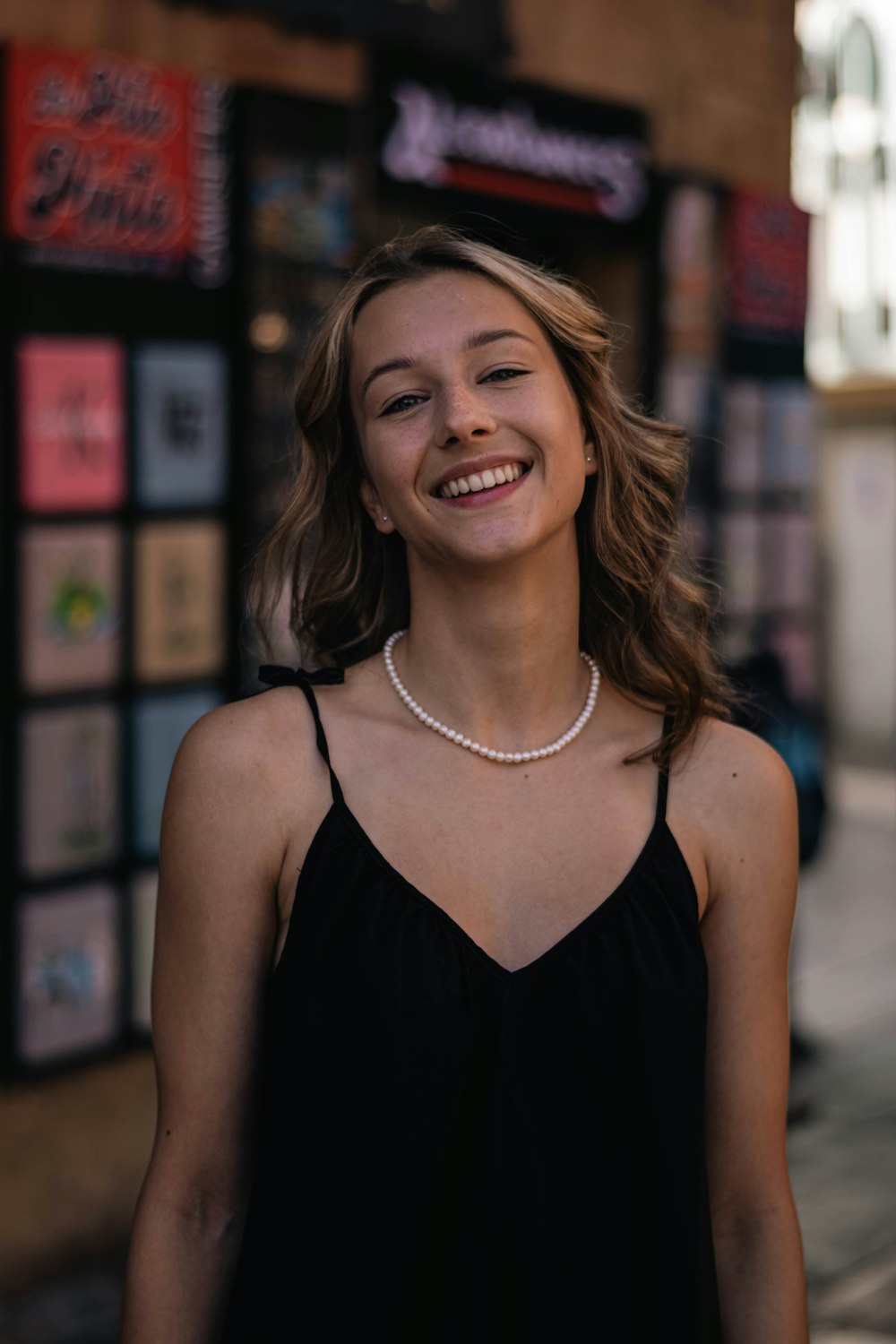 a woman standing in front of a store with a smile on her face