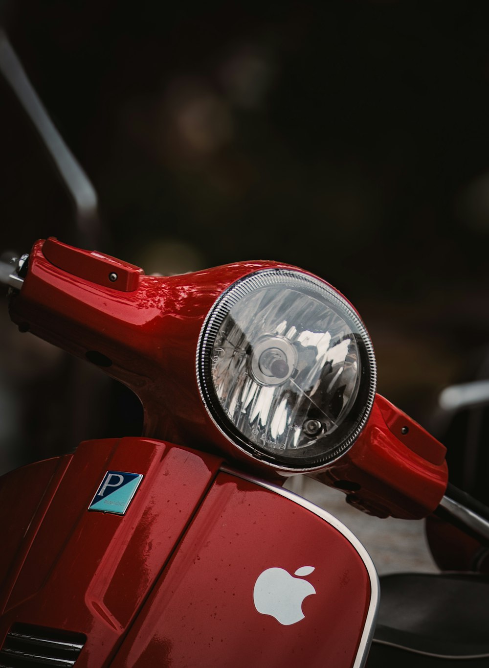 a close up of a red motorcycle with an apple logo on it