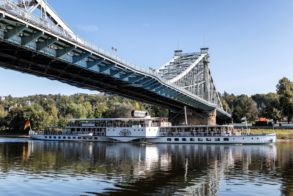 a large boat on a river under a bridge