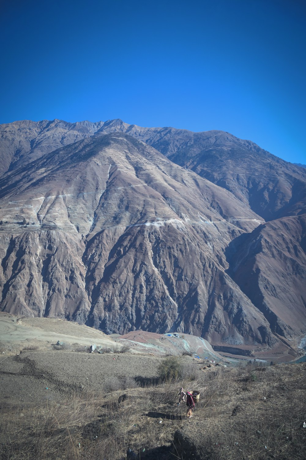 two people are hiking up a mountain side