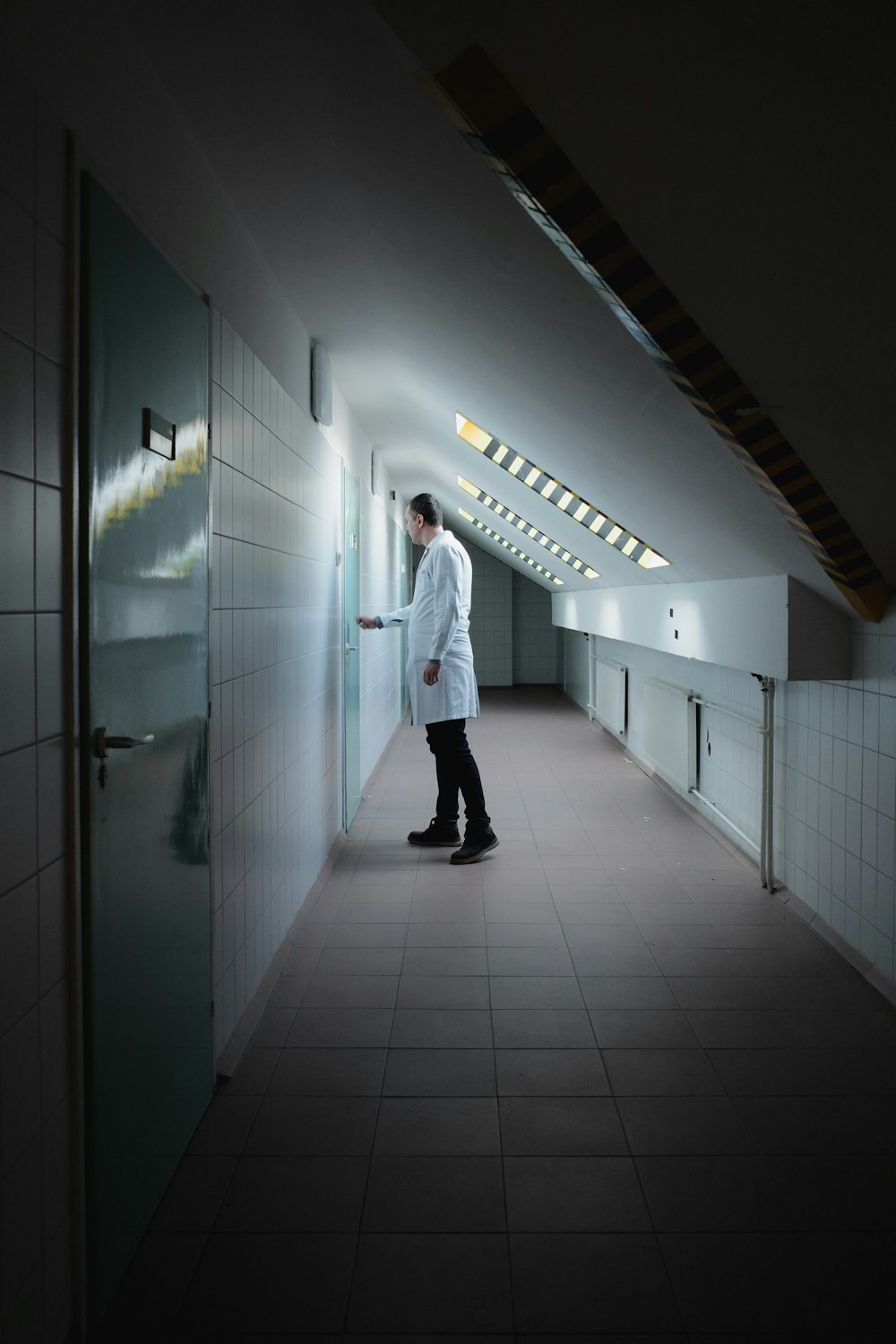 a man in a lab coat standing in a hallway