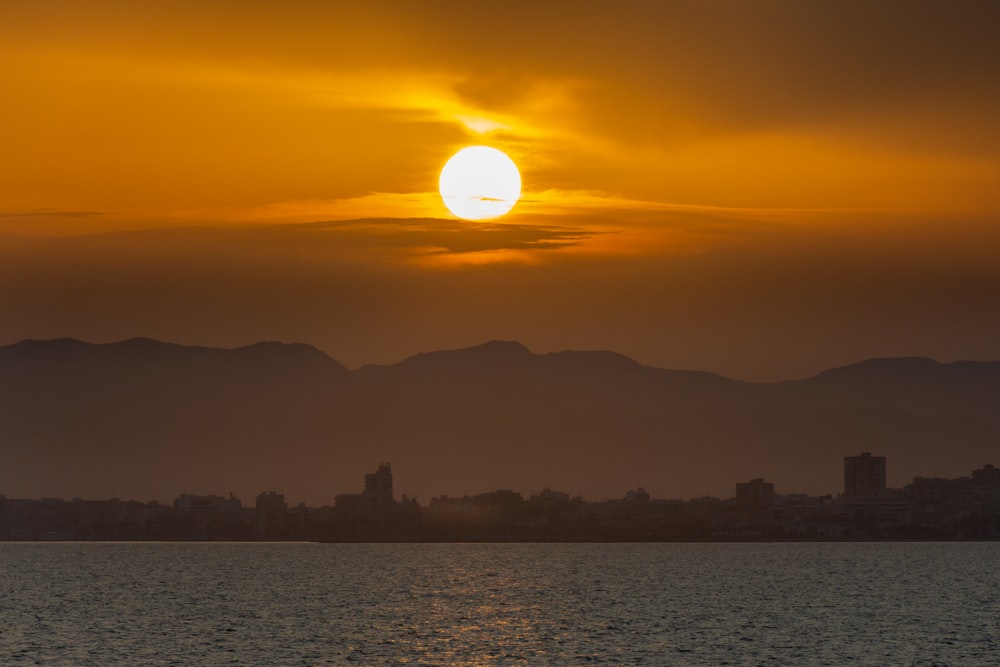 una gran masa de agua con una puesta de sol al fondo